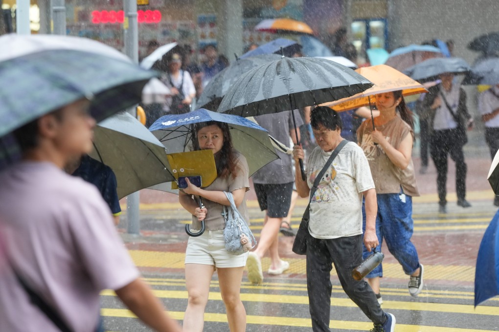 Residents cross a street under the rain in Tai Wai. Photo: Sam Tsang