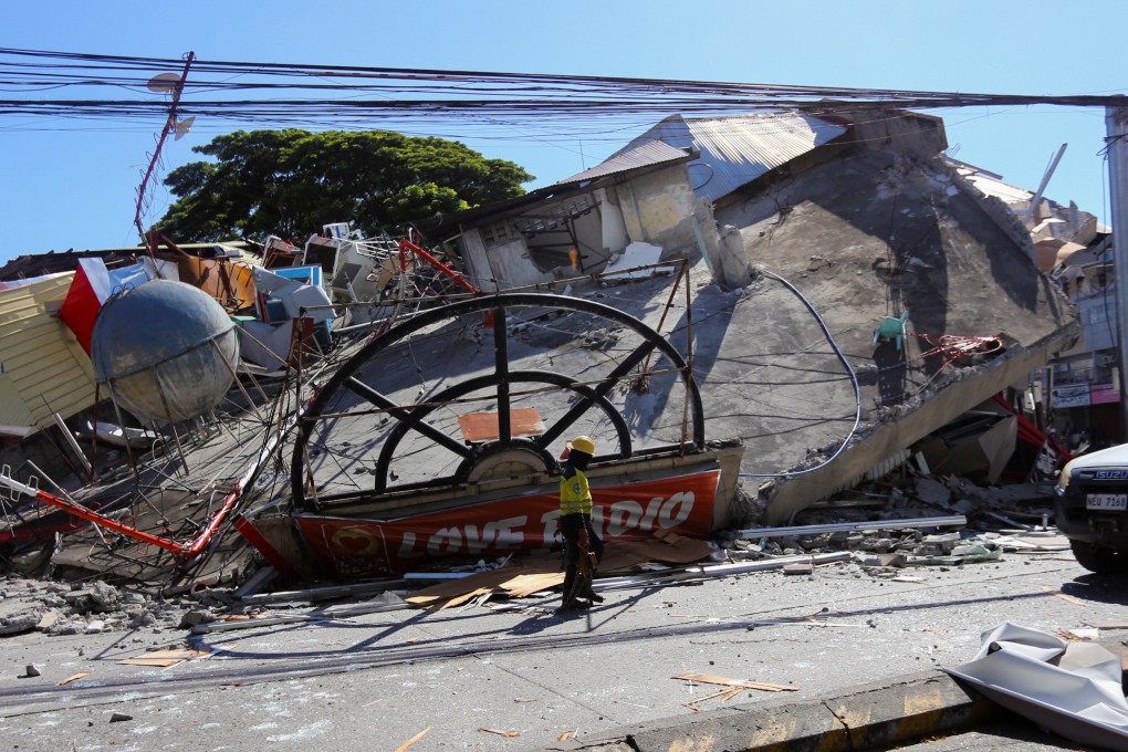 A worker walks near a collapsed building in General Santos, southern Philippines, on June 8 following the magnitude 7.8 quake. Photo: Reuters