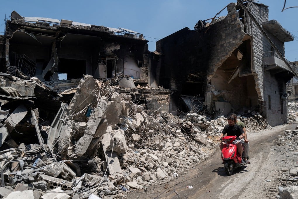 Men ride a motorcycle past buildings damaged by Israeli strikes in Nabatieh, Lebanon, on Wednesday. Photo: Reuters