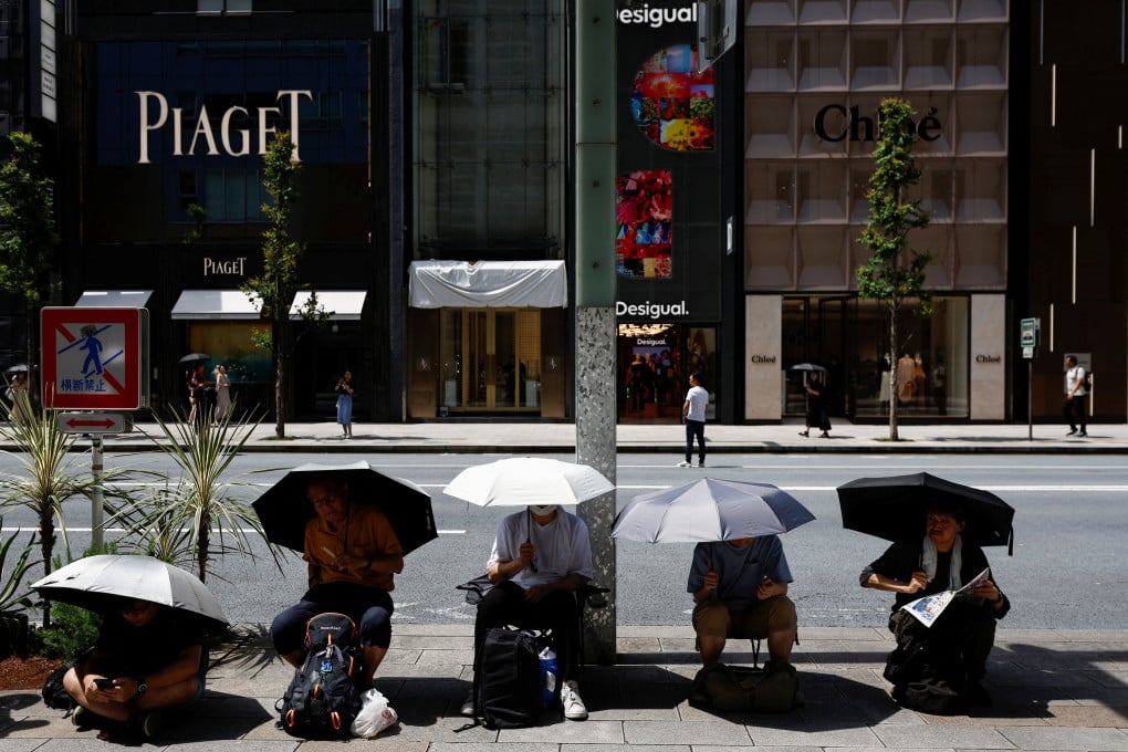 People cover themselves with umbrellas during a hot summer day at Ginza in Tokyo on August 11, 2024. Photo: Reuters