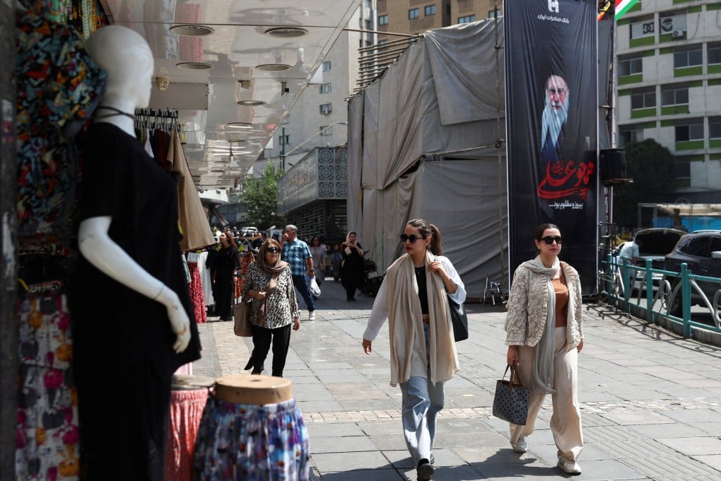 People walk past a banner with a picture of Iran’s late Supreme Leader Ayatollah Ali Khamenei in Tehran on Wednesday. Photo: WANA/Reuters