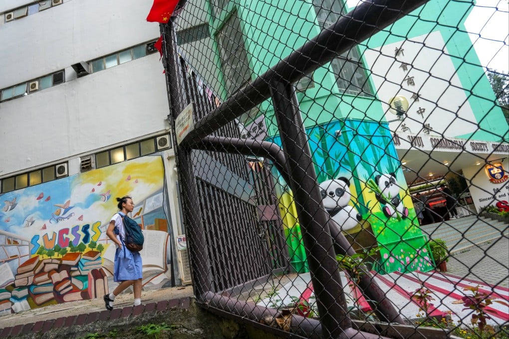 A student walking into the San Wui Commercial Society Secondary School in Tuen Mun on May 29. The school has fired its principal after he swore at security guards during a student trip to Singapore last month. Jelly Tse