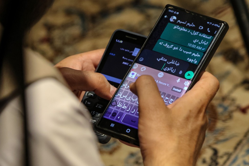 A man uses smartphones in Kabul on Tuesday. Photo: EPA
