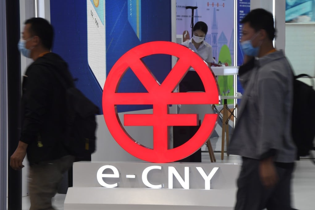 People walk past a sign promoting the digital yuan, or e-CNY, at an expo in Beijing. Photo: Xinhua