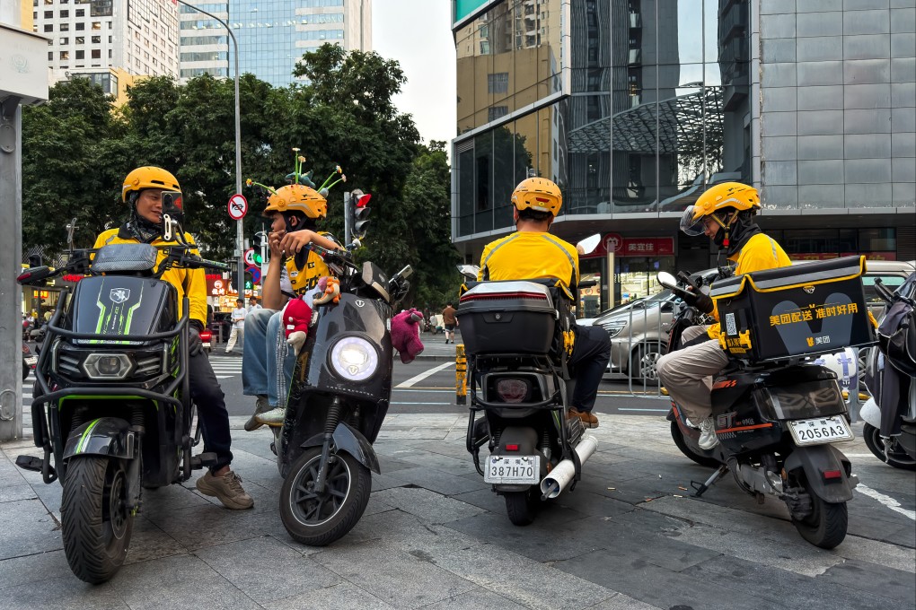 Food-delivery riders for Meituan sit on scooters while waiting for orders at a street intersection in Shenzhen, Guangdong province. Photo: Getty Images