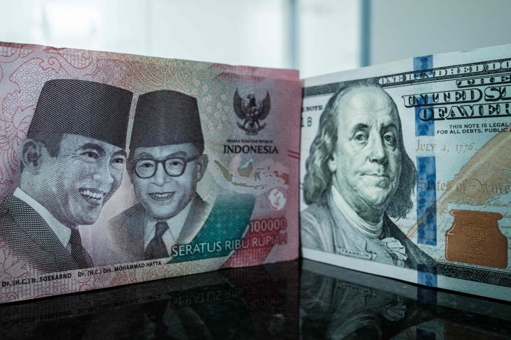 An Indonesian rupiah banknote pictured next to a US dollar banknote at a currency exchange office in Jakarta. Photo: AFP