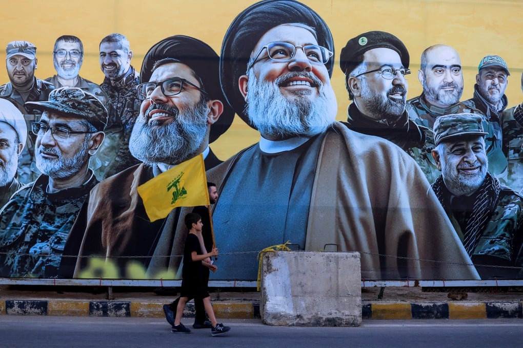 A man walks with a boy carrying a Hezbollah flag past a mural outside Beirut, Lebanon, on Wednesday. The US-Iran deal includes provisions for an immediate and permanent ceasefire on all fronts, including Lebanon. Photo: Reuters