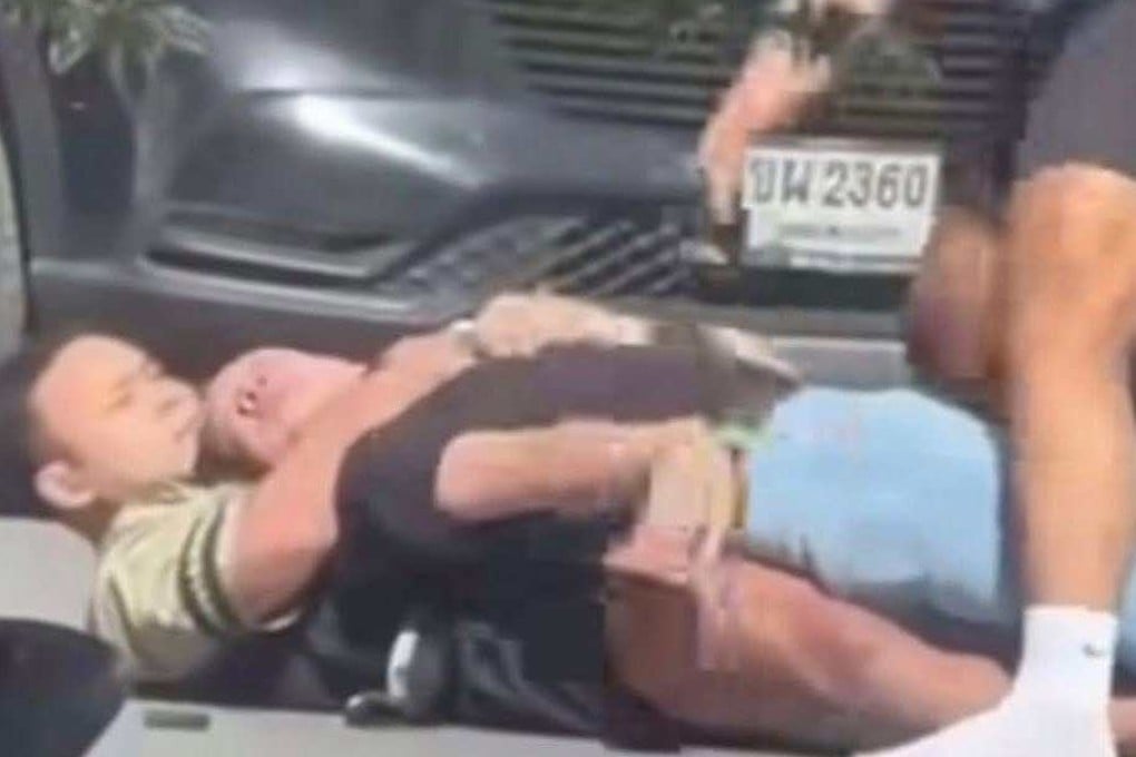 Two fitness instructors grab a suspect who allegedly shot his wife and her mother outside a gym near a market in Buriram province, Thailand, on Wednesday afternoon. Photo: Facebook/Siam Buriram Rescue