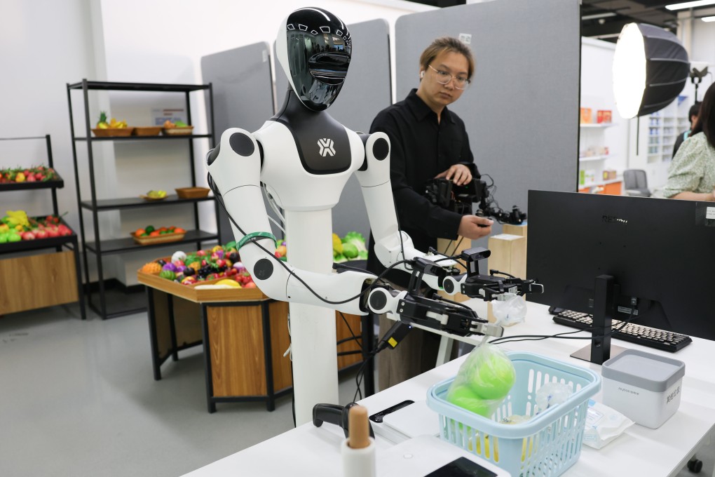A staff member collects data on a robot’s movements as it works in a simulated supermarket at the embodied intelligence robot data and training base of the Beijing Innovation Centre of Humanoid Robotics in Beijing on June 12. Photo: Xinhua