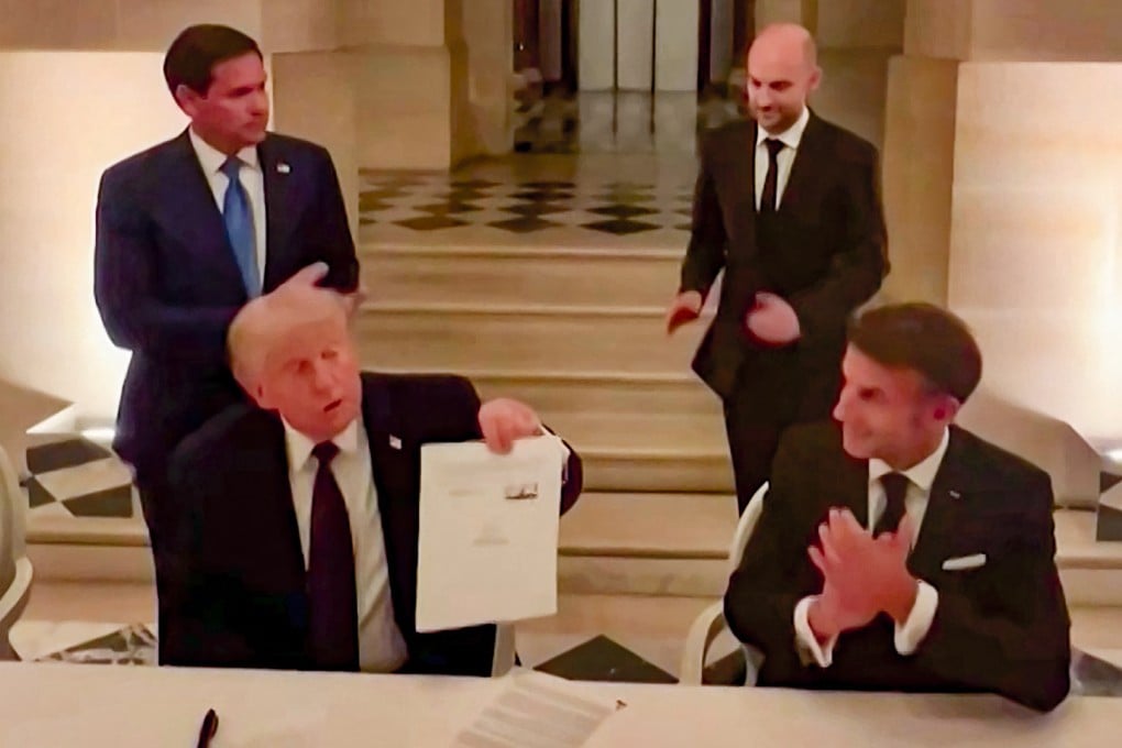 US President Donald Trump (left) shows his signed peace deal with Iran while France’s President Emmanuel Macron applauds on Wednesday. Photo: X/ EmmanuelMacron via AFP
