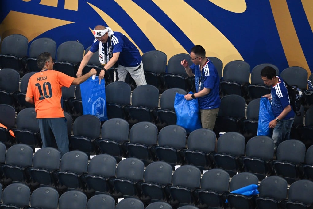 Japanese fans pick up trash in the stadium following the World Cup match between the Netherlands and Japan in Arlington, US, on Sunday. Photo: AP