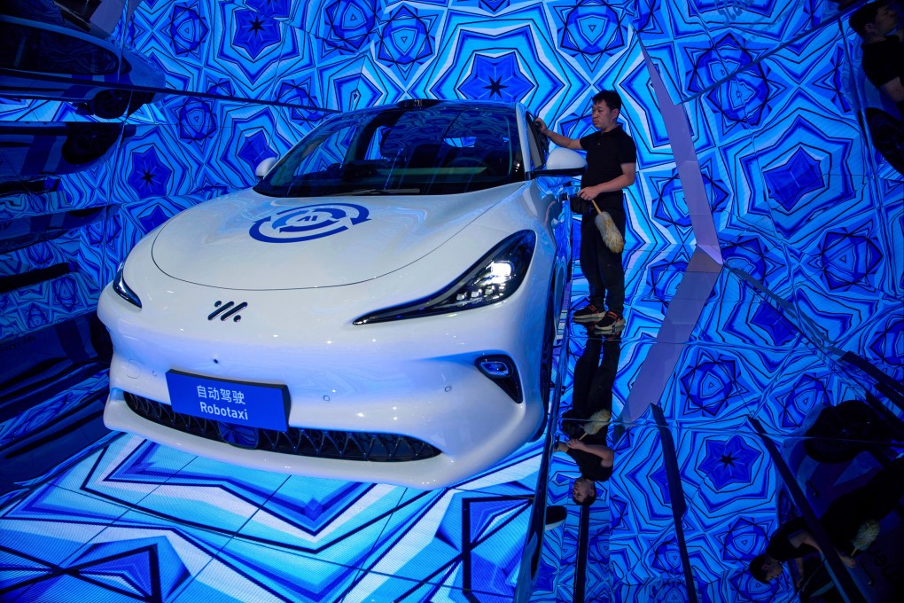 A worker cleans a Momenta robotaxi at last year’s Shanghai auto show. Photo: AP