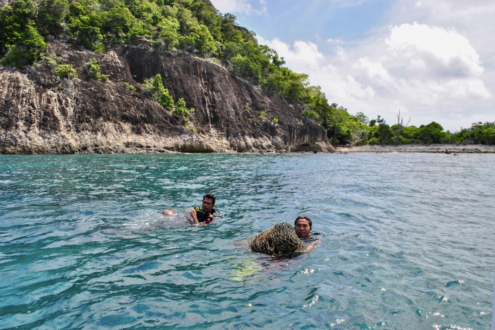 Divers retrieve an abandoned fishing net in Bawah Reserve, Indonesia’s Anambas Islands. Photo: Carolyn Beasley