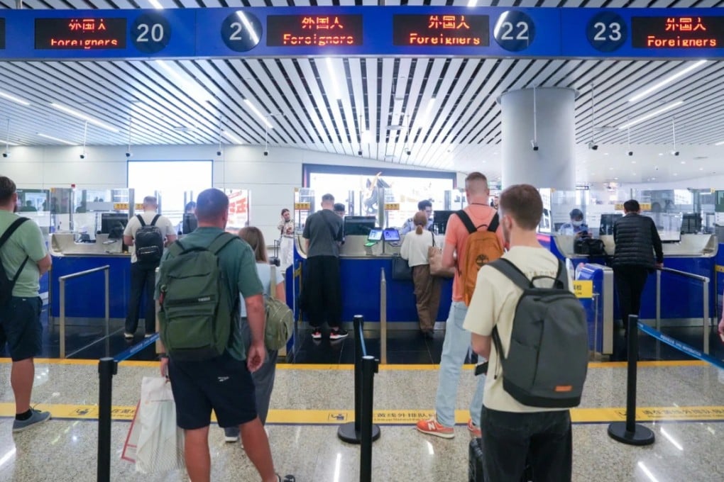 Russian nationals line up for immigration processing at the Baiyun Airport in Guangzhou. Photo: gzdaily