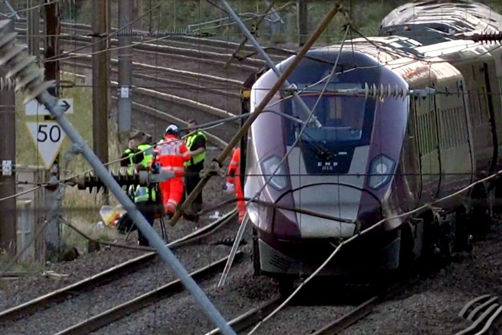 Emergency personnel work on a train on the tracks outside Bedford, England, after two trains collided on Friday. Photo: PA via AP