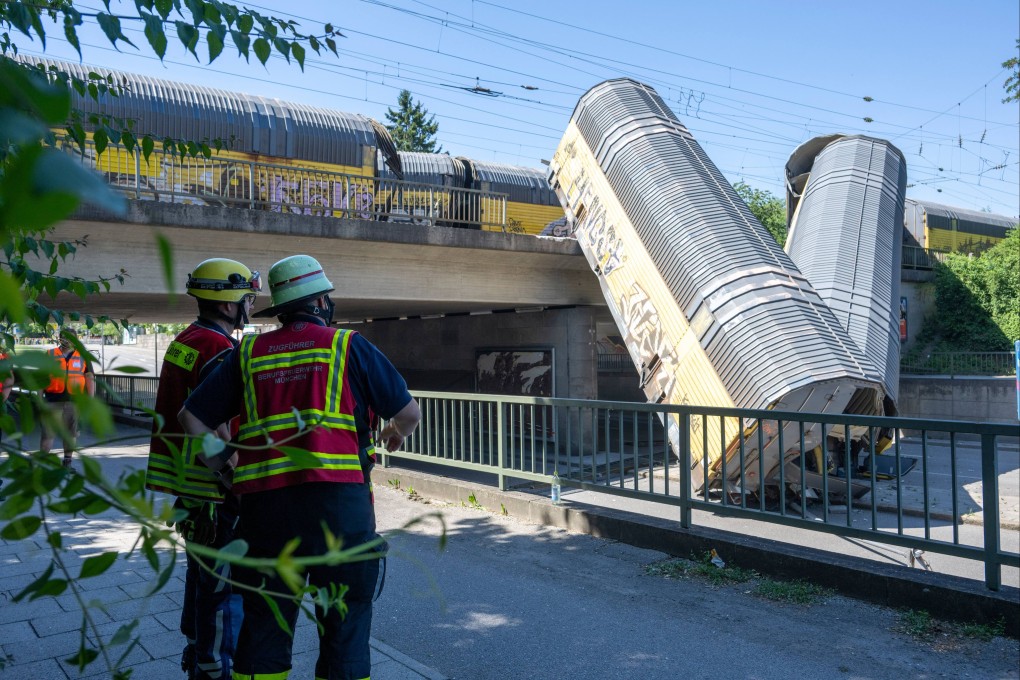 Firefighters examine the two cars of a freight train that fell from a bridge during the night. Photo: dpa
