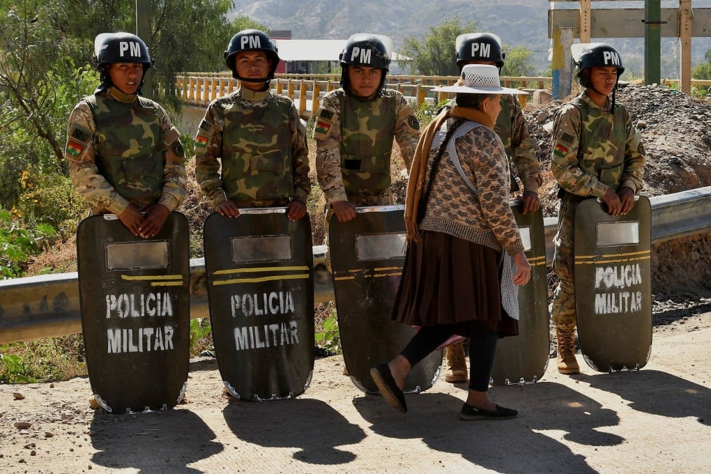 Military personnel stand in formation as they are deployed, while a woman walks past in front of them, after Bolivian President Rodrigo Paz declared a nationwide state of emergency following weeks of violence and blockades, in Cochabamba, Bolivia, on Saturday. Photo: Reuters