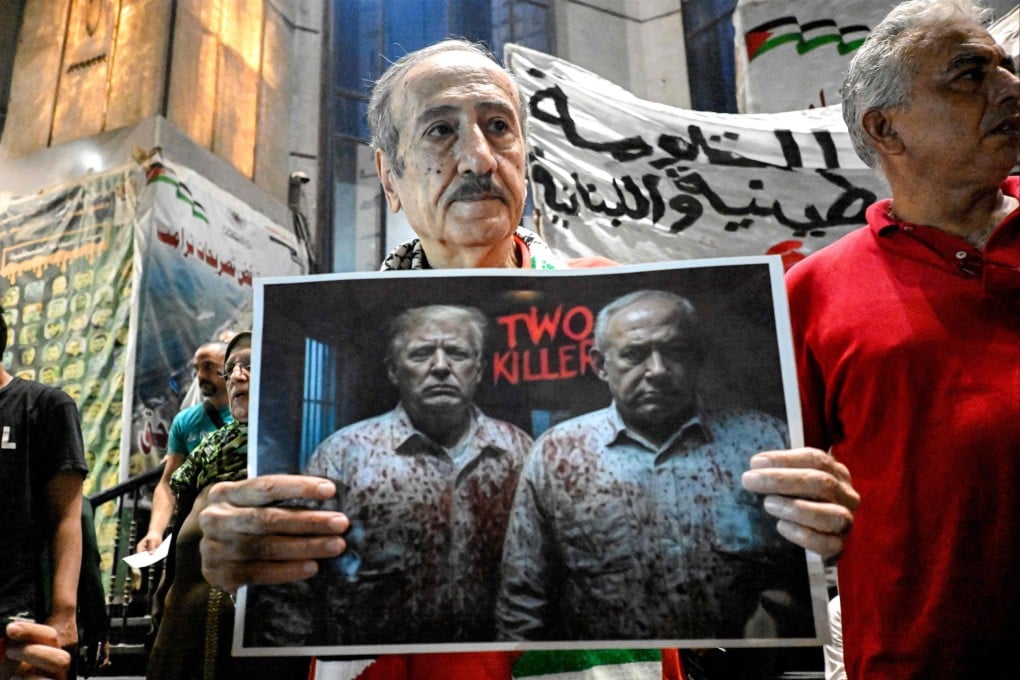 A demonstrator holds a sign critical of US President Donald Trump and Israeli Prime Minister Benjamin Netanyahu during a protest in solidarity with journalists in Gaza Strip and condemning the killing of Al Jazeera reporters days earlier, organised by journalists outside Egypt’s Press Syndicate in Cairo, on August 13 last year. Photo: AFP