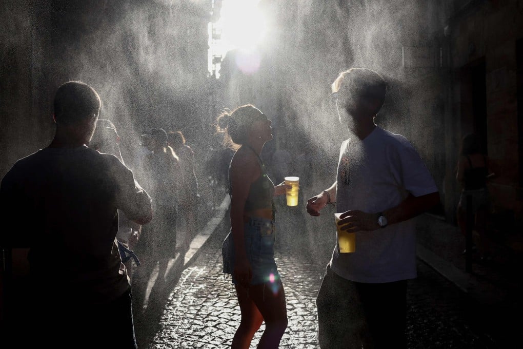 Partygoers cool off under a water mist during the annual ‘Fête de la Musique’ street music festival in Bordeaux, France. Photo: AFP