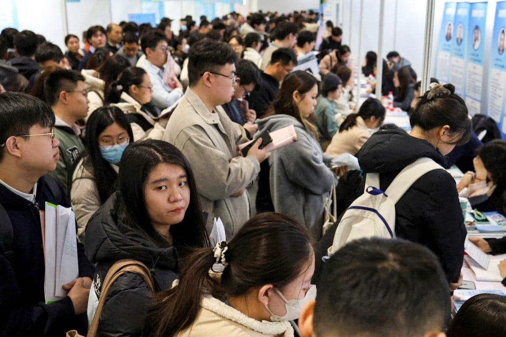 People line up at career-guidance booths during a job fair in Beijing on March 14. Photo: Reuters