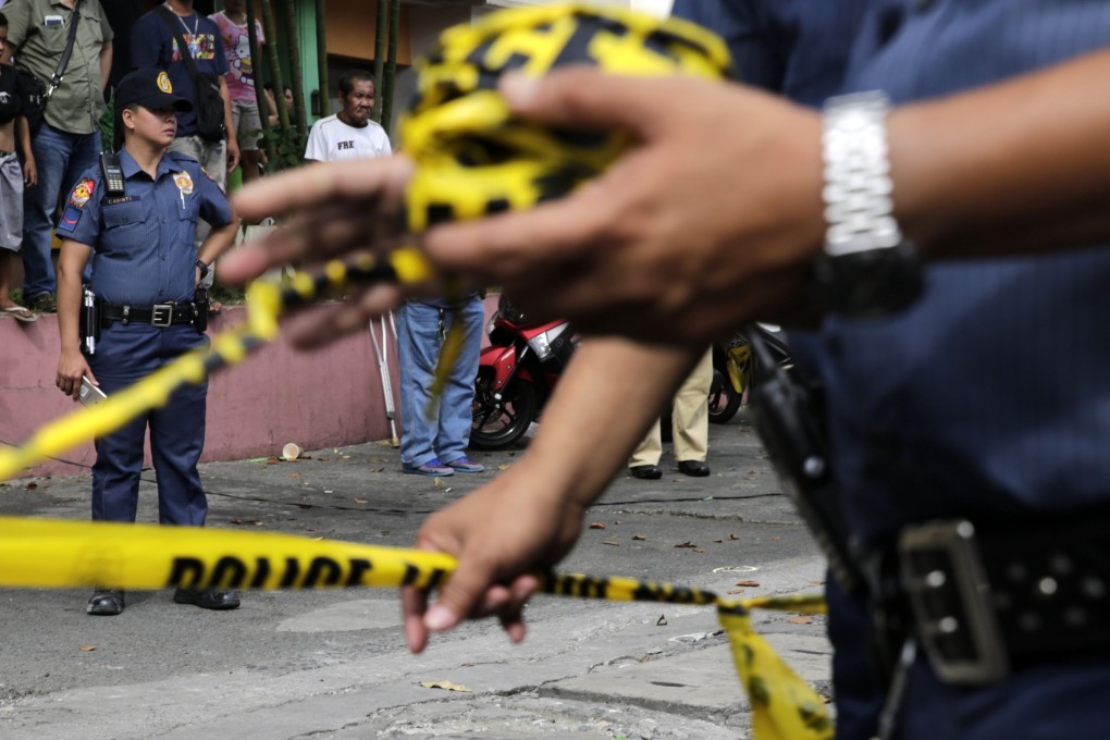 Filipino officers install police line at a scene of a crime. Photo: EPA-EFE
