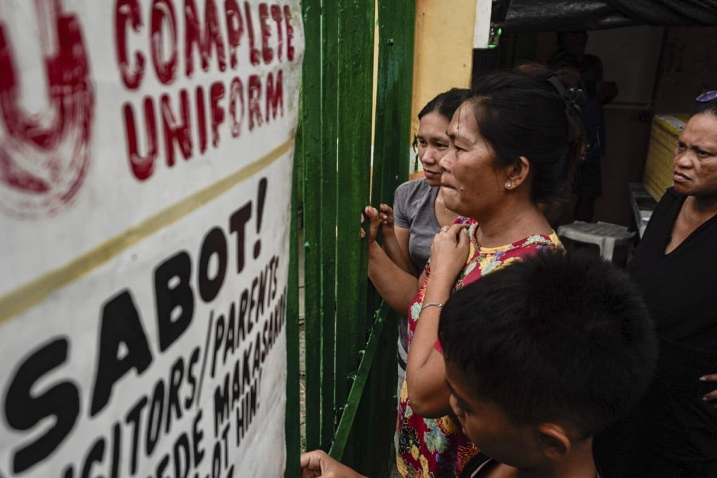 People look through the gates of San Jose National High School in Tacloban City, Philippines, on Monday. Photo: EPA