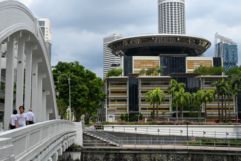 People walk across a bridge near the Supreme Court (right) in Singapore. Photo: AFP