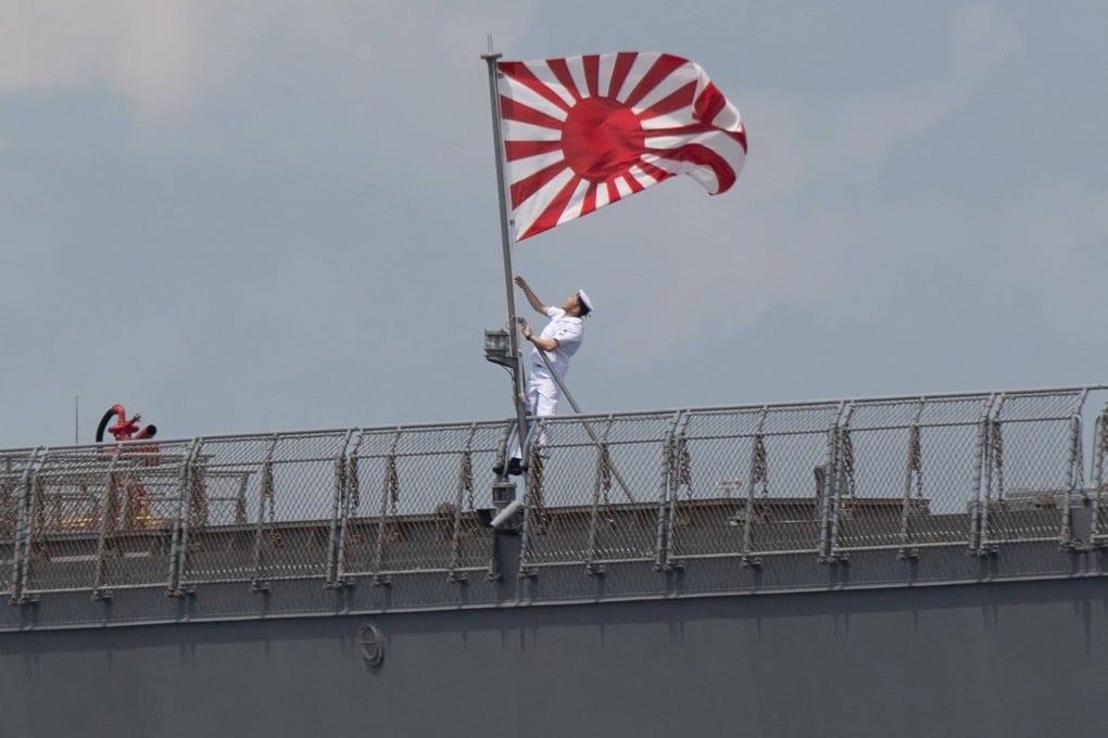 A sailor raises the Japan Maritime Self-Defence Force ensign on board the JS Ise, a helicopter destroyer, as it docks at the international port in Manila in June last year. Photo: AFP