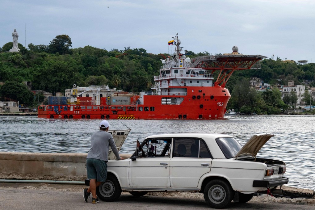 A man inspects a car in Havana as a humanitarian aid ship arrives in port. Photo: AFP