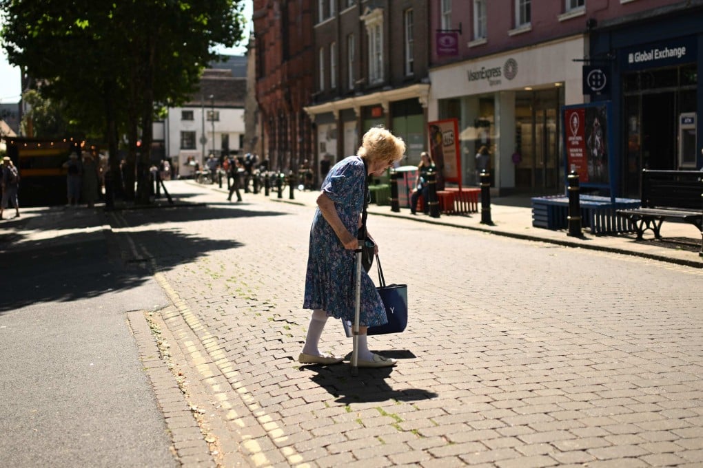 A woman walks past shops during a heatwave in England’s northern city of York on Wednesday. Britain’s meteorological office has issued a very rare red heat warning -  only issued once before - for Wednesday and Thursday, as temperatures could soar to 40 degrees. Photo: AFP