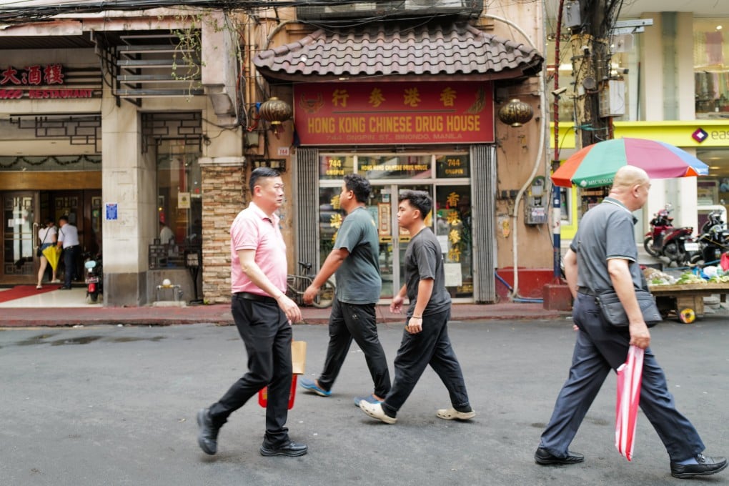 Chinese-Filipinos walk along Binondo in Manila. The community has been involved in disaster relief efforts in the Philippines for many years. Photo: Jeoffrey Maitem