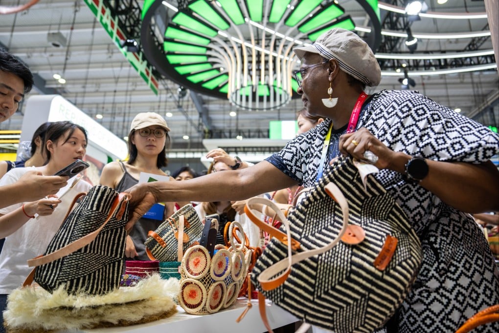 An exhibitor (right) shows her bags to visitors during the fourth China-Africa Economic and Trade Expo in Changsha, Hunan province, on June 13, 2025. Photo: Xinhua