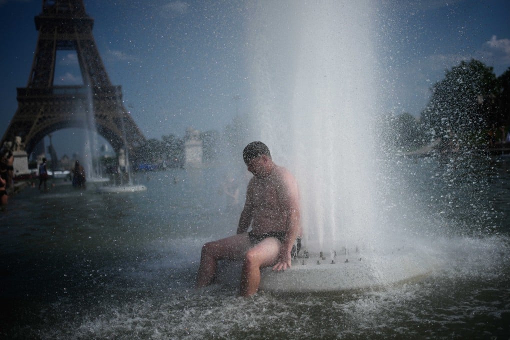 A person cools off at Trocadero fountain near the Eiffel Tower during a heat wave in Paris on Wednesday. Photo: ap