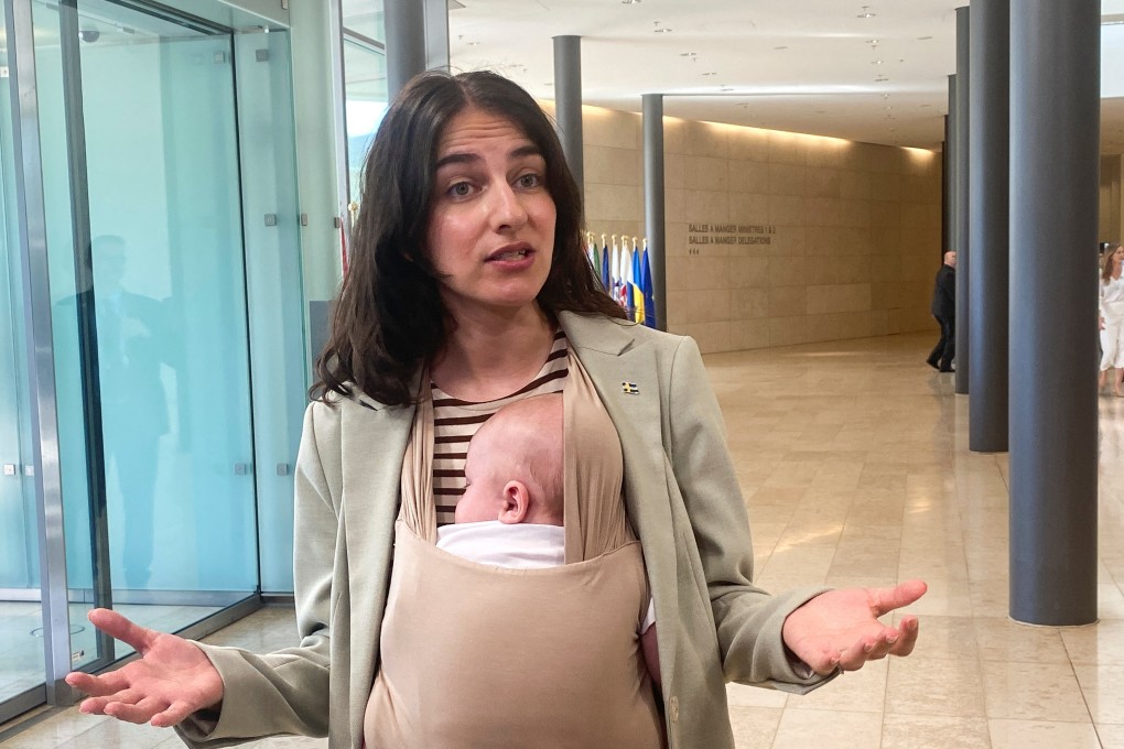 Swedish Environment Minister Romina Pourmokhtari, carrying her baby Adam, speaks to journalists before a meeting of EU environment and climate ministers, in Luxembourg on Thursday. Photo: Reuters