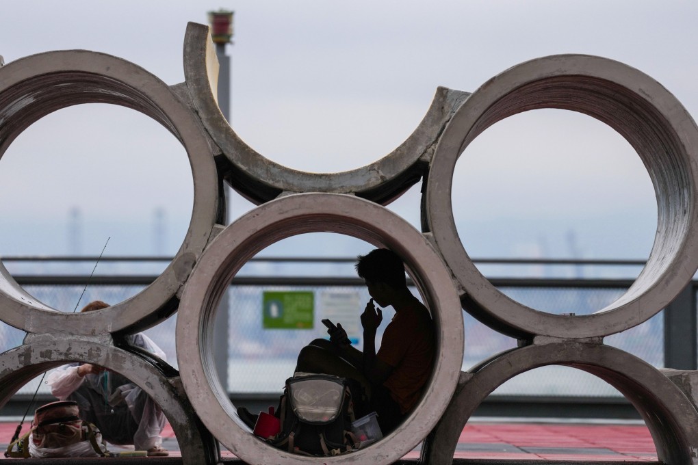 A man looks at his phone at the at the Sai Ying Pun waterfront on May 5. Photo: Karma Lo