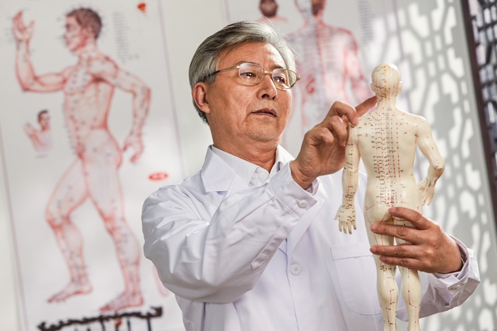 A traditional Chinese medicine doctor looks at a research model of acupuncture points on the human body. Acupuncture is one of several treatments traditionally prescribed in TCM to ensure transitions between later life cycles feel smooth. Photo: Shutterstock