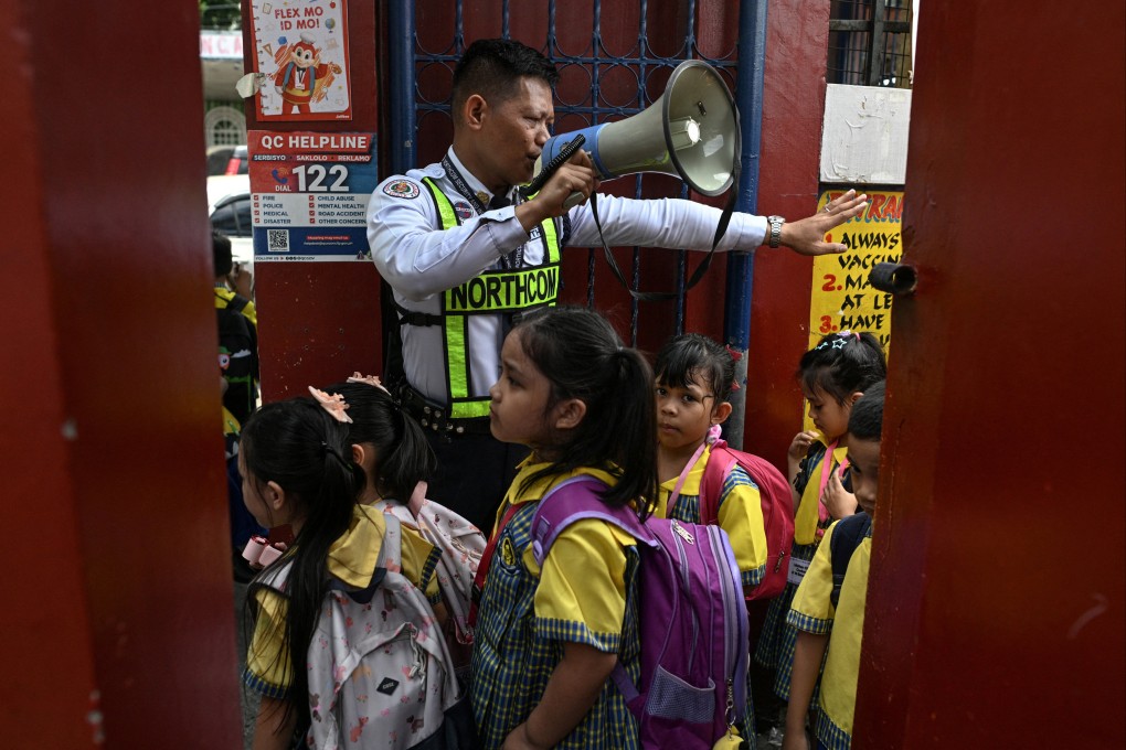 A security guard guides students as they enter an elementary school, a day after a school shooting in the city of Tacloban southeast ​of Manila, in Quezon City, Philippines, on Tuesday. Photo: Reuters