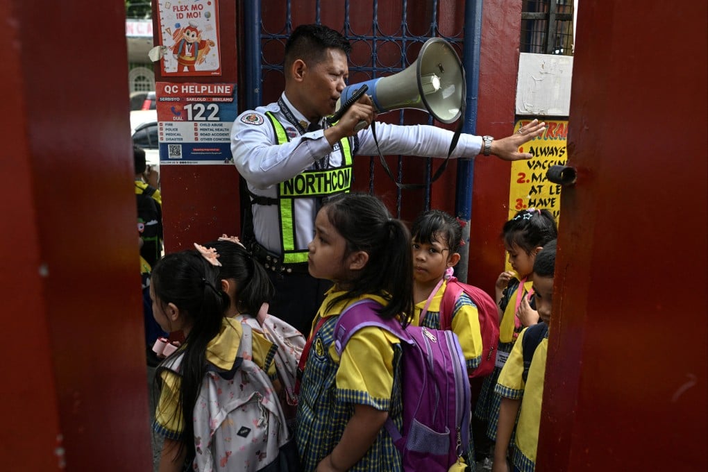 A security guard guides students as they enter an elementary school, a day after a school shooting in the city of Tacloban southeast of Manila, in Quezon City, Philippines, on Tuesday. Photo: Reuters