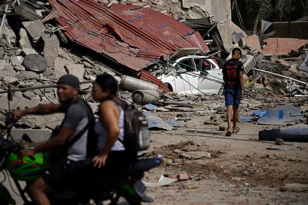 People walk and ride past collapsed structures and debris following an earthquake in Catia La Mar, Venezuela, on Wednesday. Photo: AFP
