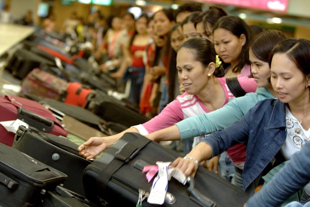 Filipino domestic workers collect their bags from a baggage carousel at Manila’s airport in 2006 after taking an emergency flight home to avoid war in Lebanon. Photo: AFP