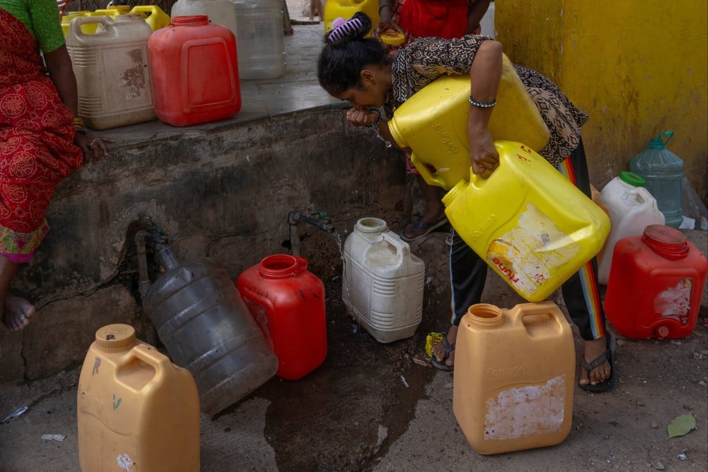A slum dweller checks the quality of water from a public tap in Mumbai, India, on June 20. Photo: AP