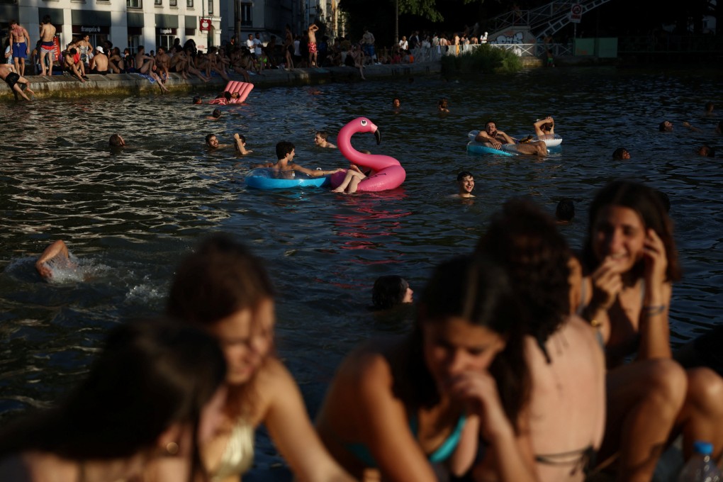 People swim in the Canal Saint-Martin on Friday after public swimming was permitted in certain areas due to high temperatures amid a heatwave in Paris. Photo: Reuters