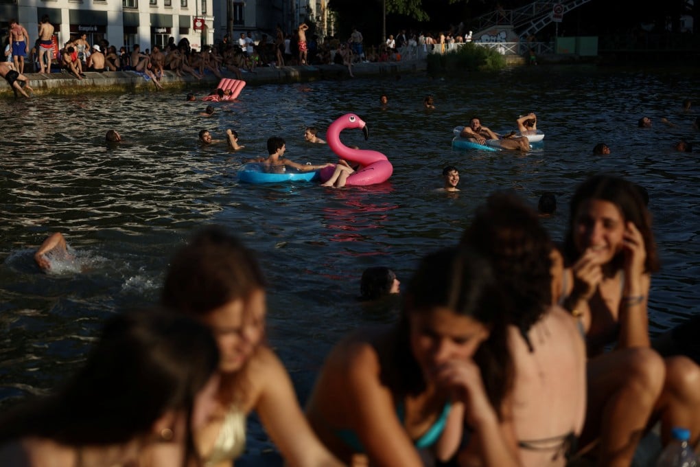 People swim in the Canal Saint-Martin on Friday after public swimming was permitted in certain areas due to high temperatures amid a heatwave in Paris. Photo: Reuters