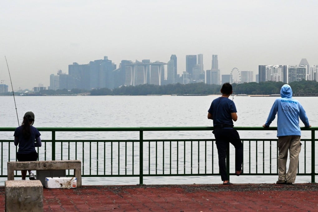 People look out from a jetty overlooking the city skyline in Singapore. Photo: AFP