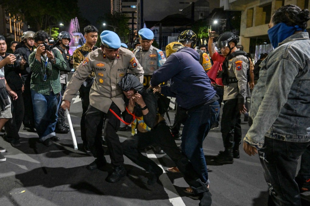 Indonesian police arrest a student following clashes during protest in Surabaya on Friday. Photo: AFP