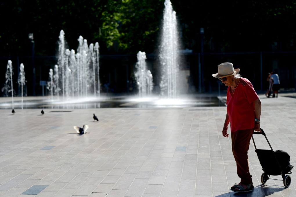 A woman walks near water fountains in Beziers, southern France on Monday. The latest bout of exceptionally high temperatures to hit Europe has seen outdoor events cancelled, transport disrupted, schools shut and office workers told to work from home. Photo: AFP