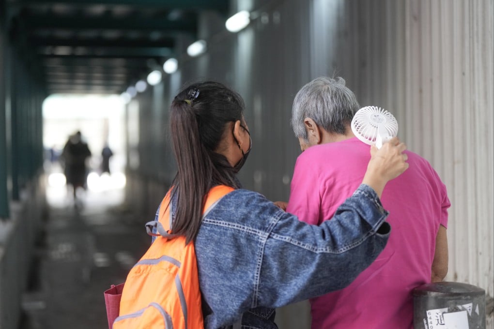 A woman tries to cool an elderly person in To Kwa Wan on July 14, 2025. Photo: Sam Tsang