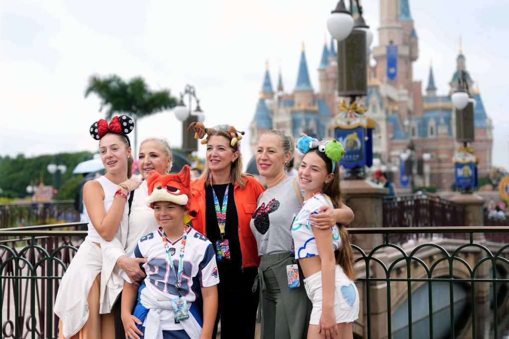 Tourists pose for a group photo at Shanghai Disneyland on June 16. Photo: Xinhua