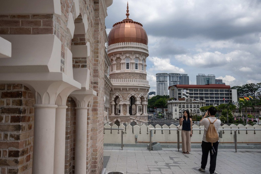Tourists take pictures with the Sultan Abdul Samad building near Merdeka Square in Kuala Lumpur on June 8. Photo: AFP