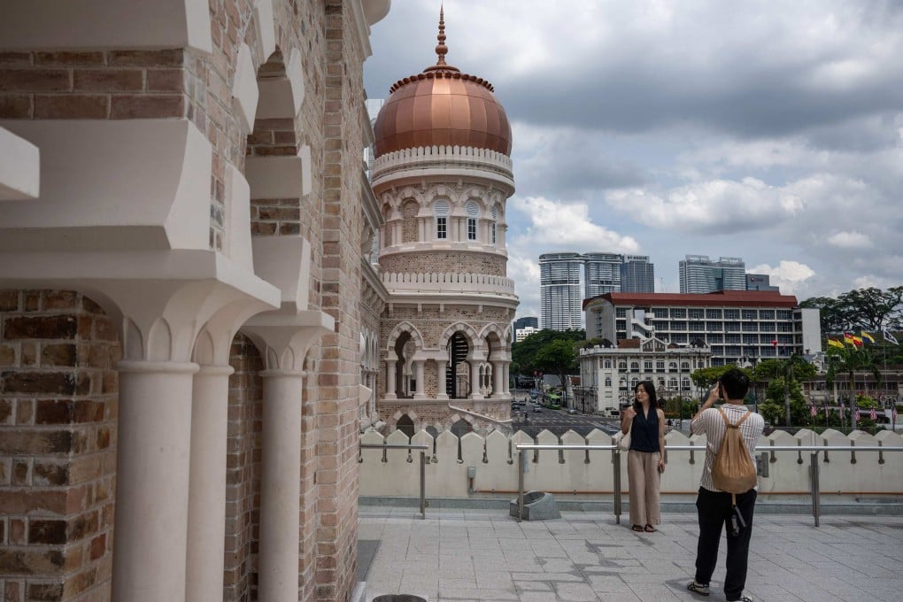 Tourists take pictures with the Sultan Abdul Samad building near Merdeka Square in Kuala Lumpur on June 8. Photo: AFP